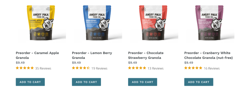 A lineup of Angry Pika Food Co. granola breakfasts in colorful packaging on a rustic wooden surface.