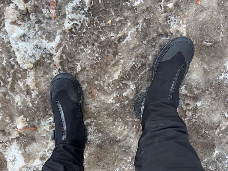 Top-down view of La Sportiva Cyklon Cross GTX shoes standing on a slushy, icy trail during winter hiking.