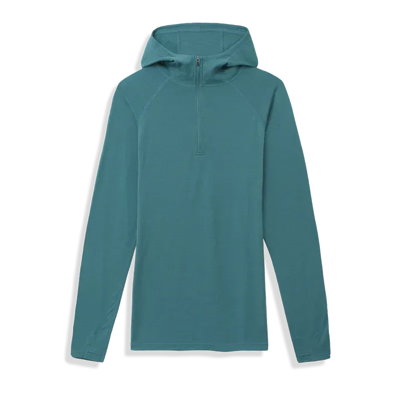  Product image of the Ibex Indie Hoody in teal, laid flat to show hood, half-zip front, and long sleeves with thumb loops.
