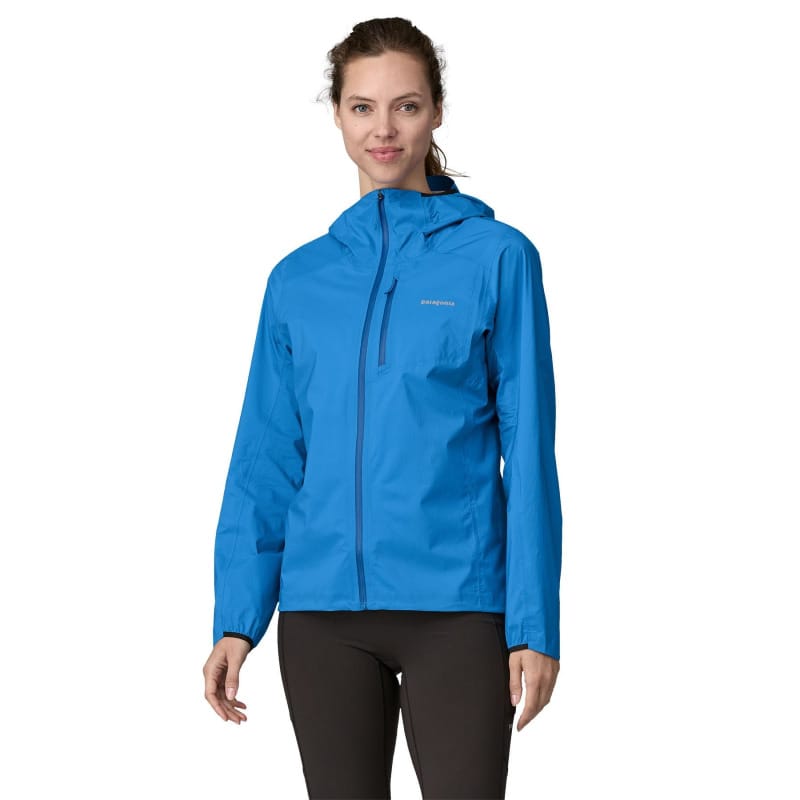Woman wearing the Patagonia Storm Racer jacket in bright blue, designed for trail running and fastpacking.