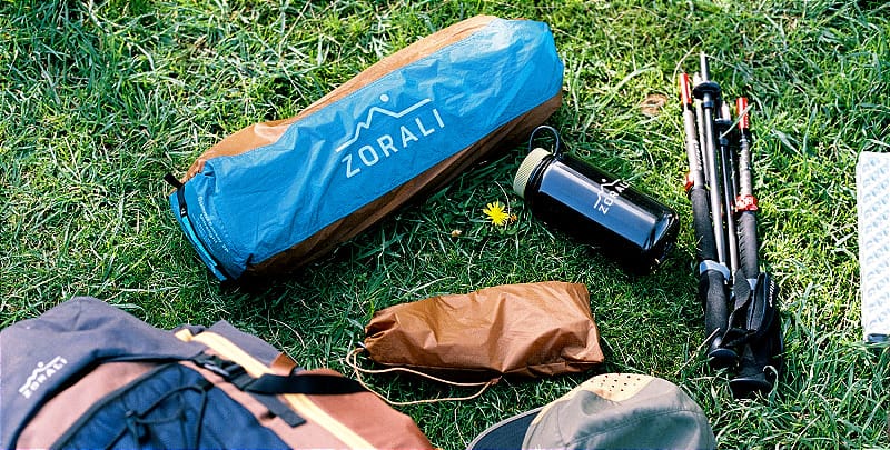     Zorali Summit-Seeker 2P Tent and poles packed down next to backpacking gear and trekking poles      Caption: Everything you need, nothing you don’t—this 2P tent packs down small and light for easy hauling into the hills 