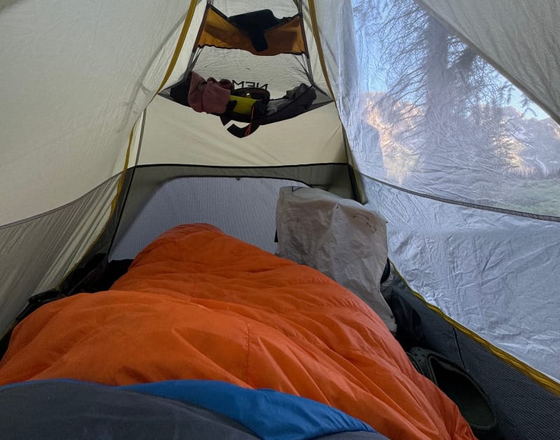 Feathered Friends Egret 20° Sleeping Bag set up inside a tent with gear and clothing nearby.