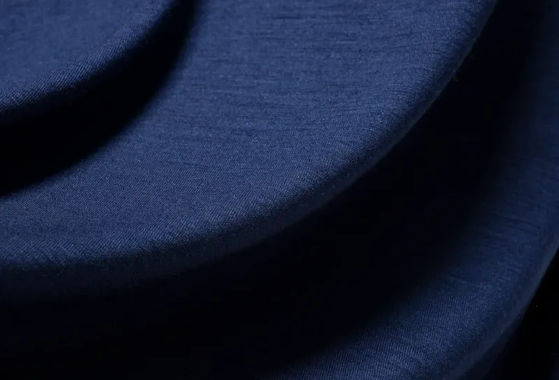  Macro photo of navy merino wool fabric, showcasing soft texture and fine weave used in Ibex outdoor apparel.