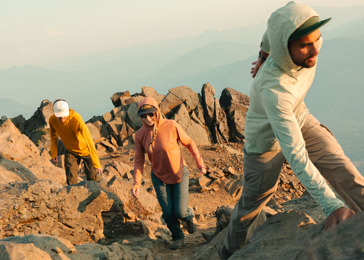 Hikers climbing a rocky mountain ridge wearing lightweight outdoor gear featured in the REI Labor Day Sale 2025.