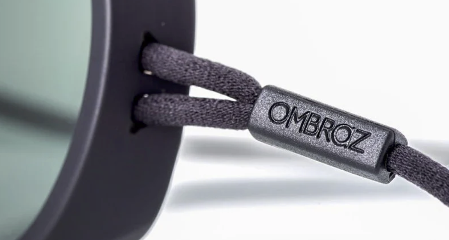 Close-up detail of Ombraz sunglasses cord made from recycled fishnet material with Ombraz branding.