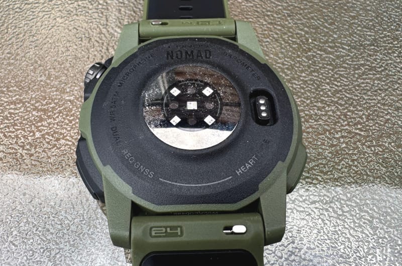 Close-up of the underside of the COROS Nomad Watch, highlighting heart rate sensor and charging contacts.