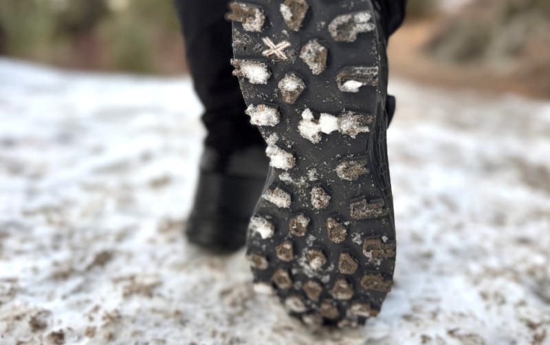 Close-up of hiking boot sole with snow and ice stuck in the tread.