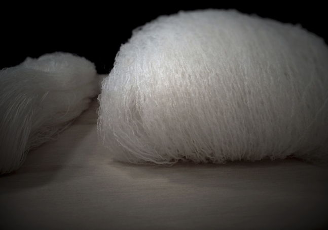 Close-up of Nuyarn merino wool fabric showing the fine twist-free fibers that enhance stretch, breathability, and durability in performance apparel.