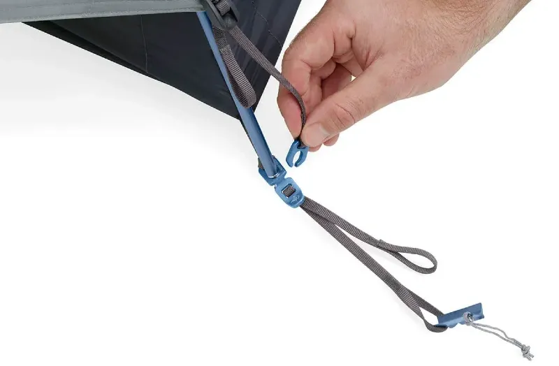 Close-up of a hand connecting Sea to Summit Telos Tent corner strap and tension adjustment system for secure pitching.