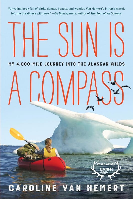 Cover of The Sun Is a Compass by Caroline Van Hemert, showing a kayaker paddling toward an iceberg with birds flying overhead.