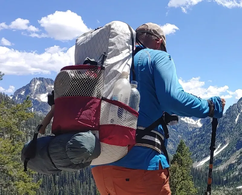 Chicken Tramper Ultralight Gear backpack loaded for backpacking in alpine mountains, featuring ultralight fabric and external mesh storage.