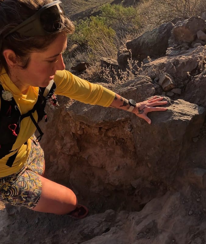 Woman hiking and scrambling on rocky desert terrain wearing La Sportiva Bushido III trail running shoes