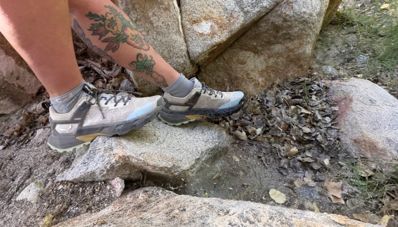 Side profile of Salewa Pedroc 2 hiking shoes stepping across granite rocks on a desert hiking trail.