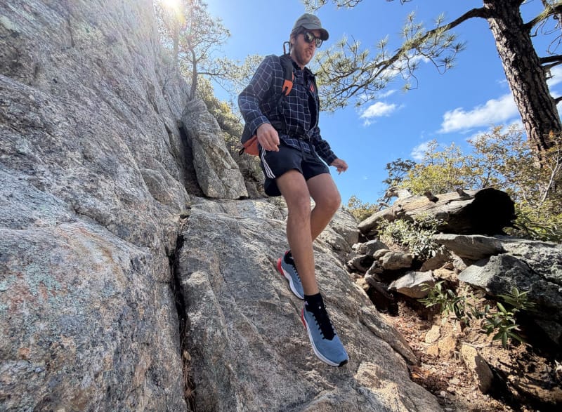 Hiker scrambling down steep granite rock while wearing Mammut Aenergy Trail Speed shoes.