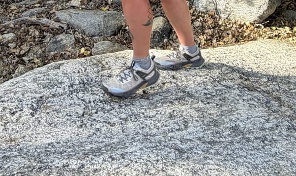 Woman hiking across desert granite slabs while wearing Salewa Pedroc 2 hiking shoes in sunny conditions.