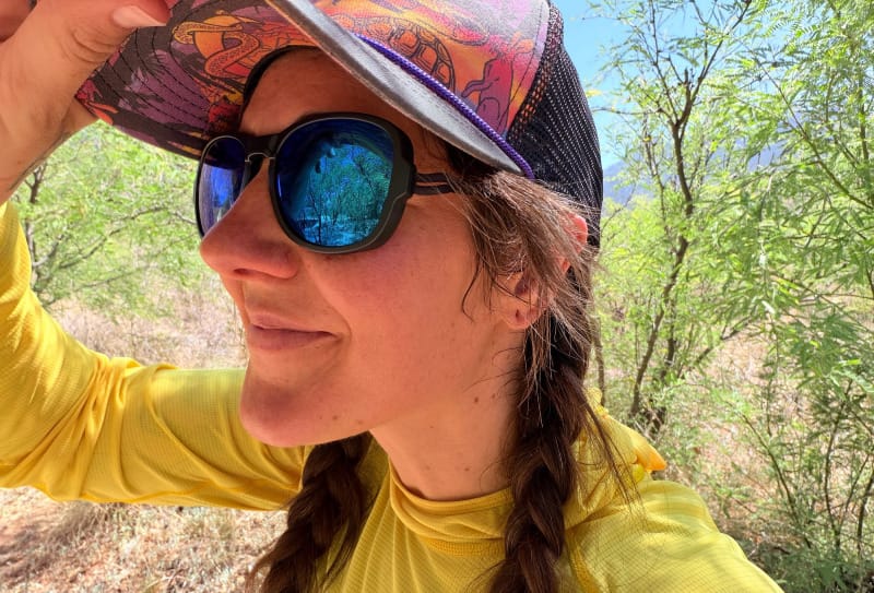 Hiker wearing Ombraz Azzuro Blue Mirror sunglasses and a sun hoodie during a bright desert hike in Arizona.