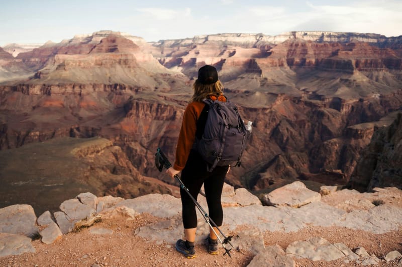 Hiker standing on the rim of the Grand Canyon wearing trail runners and a backpack while testing the best hiking shoes and trail runners for desert hiking and backpacking in 2026.