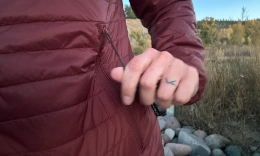 Close-up of a burgundy PAKA PAKAFILL insulated jacket being worn outdoors.