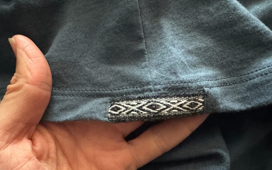 Close-up of a woven Peruvian-style textile detail sewn onto a PAKA garment.