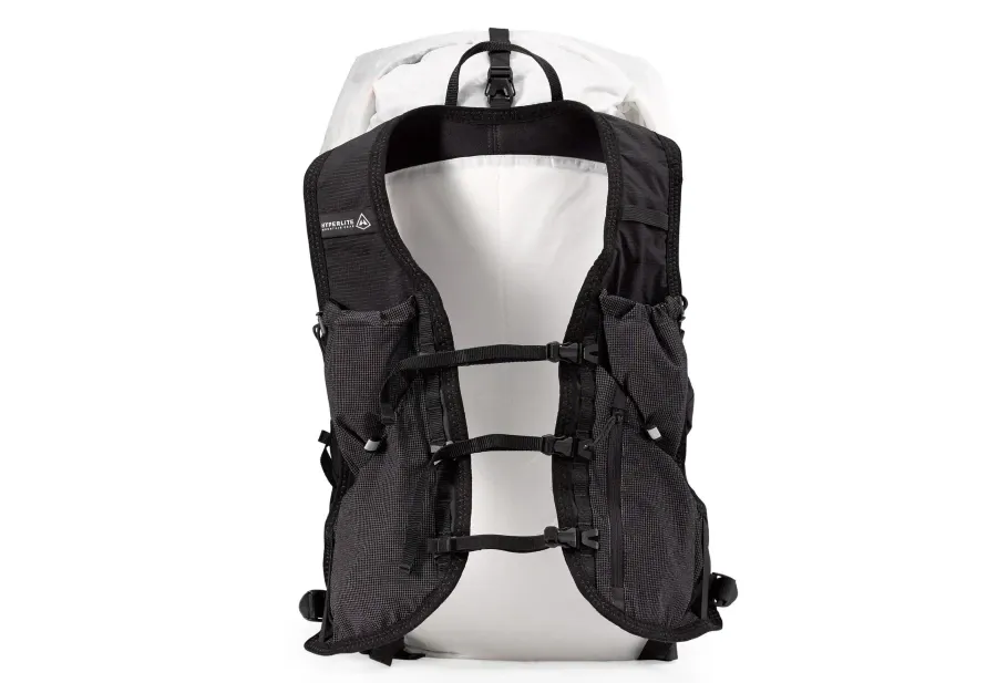 Front view of the white Hyperlite Mountain Gear Aero 28 ultralight backpack featuring black running vest shoulder straps, three sternum buckles, and integrated mesh pockets.