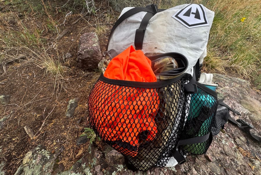 Backpack carrying a Hyperlite Mountain Gear ultralight backpack on a mountain trail.