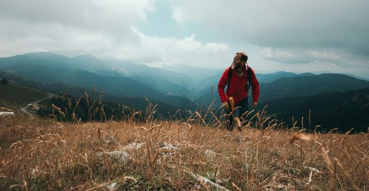 a man in a hike in a beautiful mountain lanscape. he is wearing one of out picks for top daypack of 2026