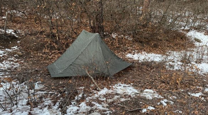The One Tent By Gossamer Gear pitched out in the woods in a snowy scene