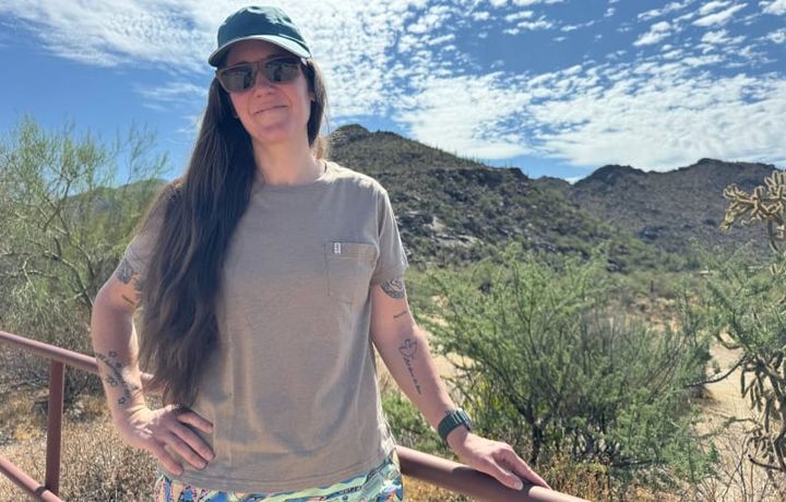  Person wearing the Paka Pocket Tee outdoors in the desert, standing in front of mountains and blue sky, showcasing the shirt’s fit and comfort.