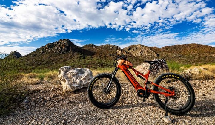 Orange Bakcou Scout eBike staged in front of dramatic desert mountains under blue skies