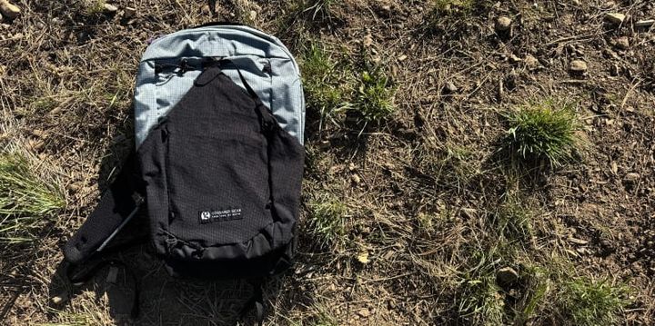 Gossamer Gear Cima 15 backpack on the ground, highlighting its compact design and front mesh pocket.