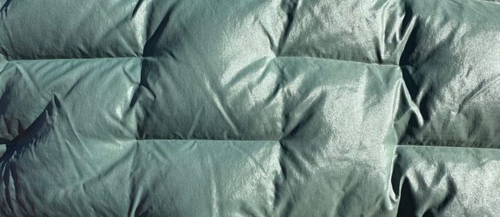  Close-up of Outdoor Vitals’ insulated technical fabric in green, showing the texture and high-loft structure of performance outdoor gear.