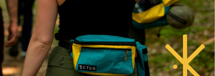 Close-up of a hiker wearing a colorful CTUG Chicken Tramper Ultralight Gear fanny pack on the trail. Handmade ultralight packs and accessories