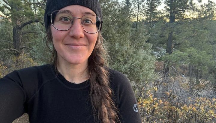 backpacker and camper wearing the black PAKA Thermal Crew base layer outdoors in a forested mountain area, showcasing natural warmth and comfort.