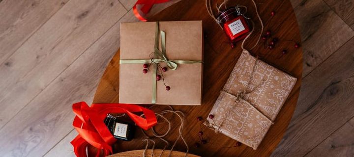 Hiker walking through a scenic desert landscape with red rock formations and a backpack, representing affordable hiking gift ideas.