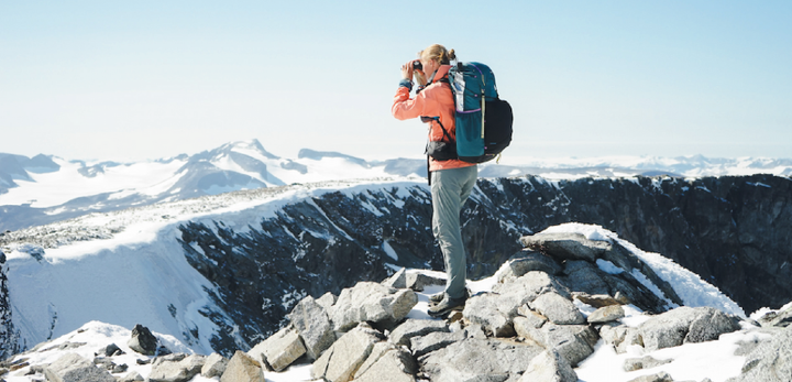 Backpacker hiking with a Gossamer Gear ultralight pack on a mountain trail, promoting the 2025 Gossamer Gear Holiday Sale with up to 30% off sitewide.