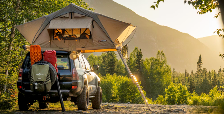 SUV with rooftop tent and overland gear parked in the mountains at sunset — luxury camping gift for outdoor lovers 2025.