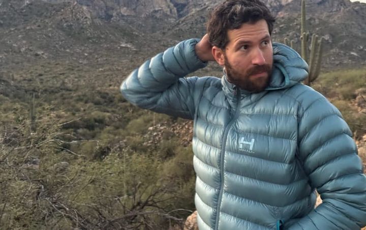 Himali Accelerator Down Jacket worn outdoors in a desert mountain landscape during a cold-weather hike