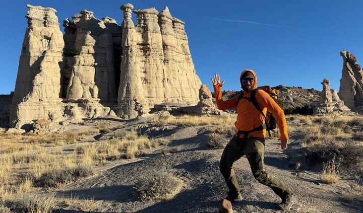 Hiker wearing the Squak Mountain Squak Grid Fleece Hoodie on a cold-weather trail, showing the fleece in real backcountry conditions.