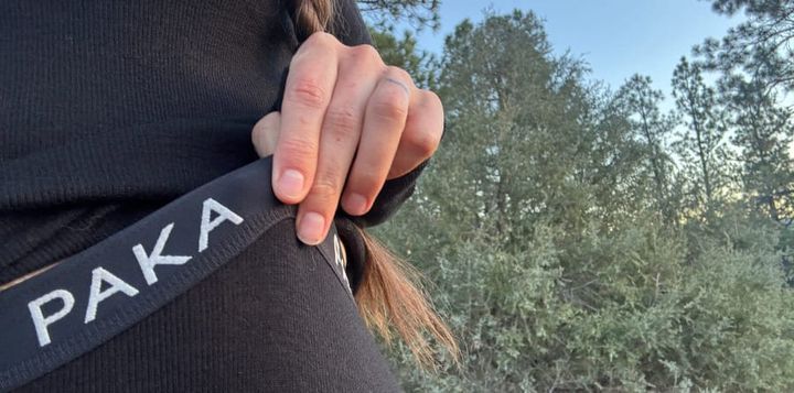 Close-up of a hiker wearing a black PAKA alpaca wool base layer outdoors.
