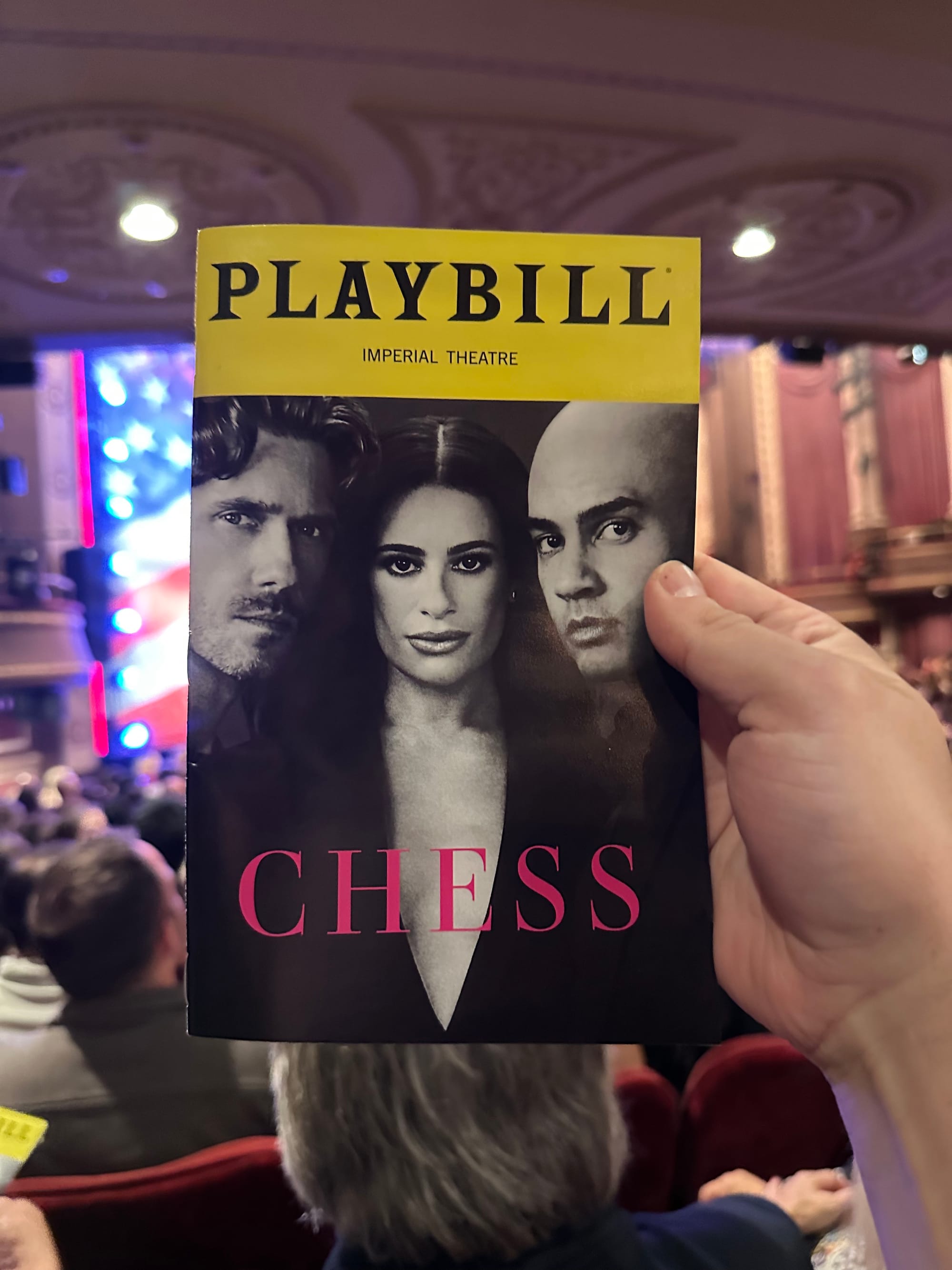 Chess playbill in front of a blurry stage.