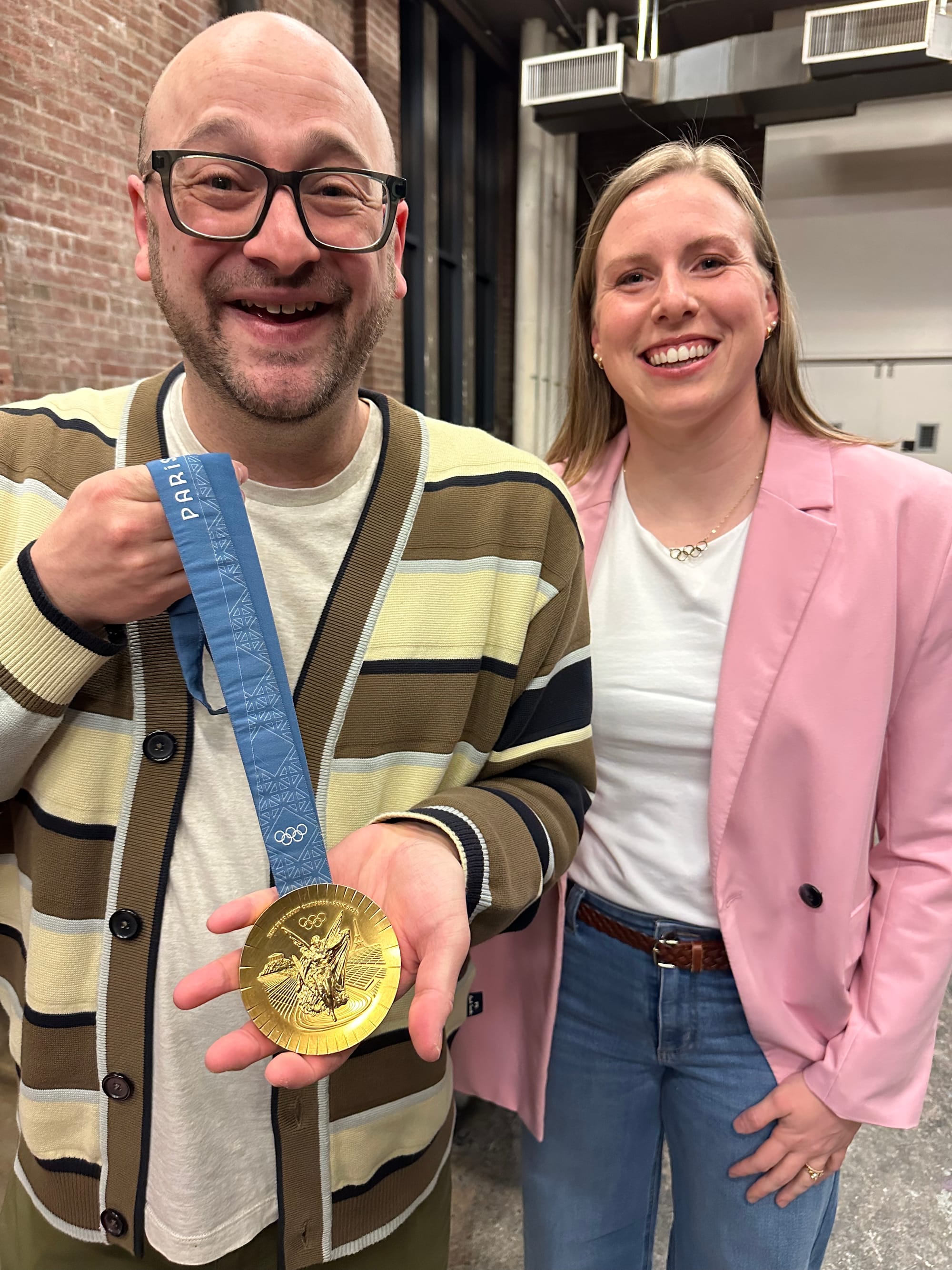 Me and Lilly King. I am wearing the sweater that Maris bought me for my birthday, a brown striped cardigan, and I'm holding Lilly King's gold medal (one of them). Lilly is next to me wearing a very stylish pink blazer.