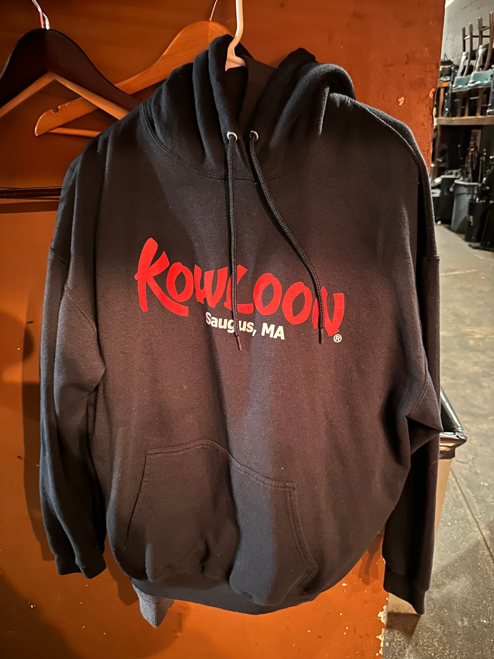 Black Kowloon Restaurant sweatshirt hanging up on the wall backstage at the Bell House.
