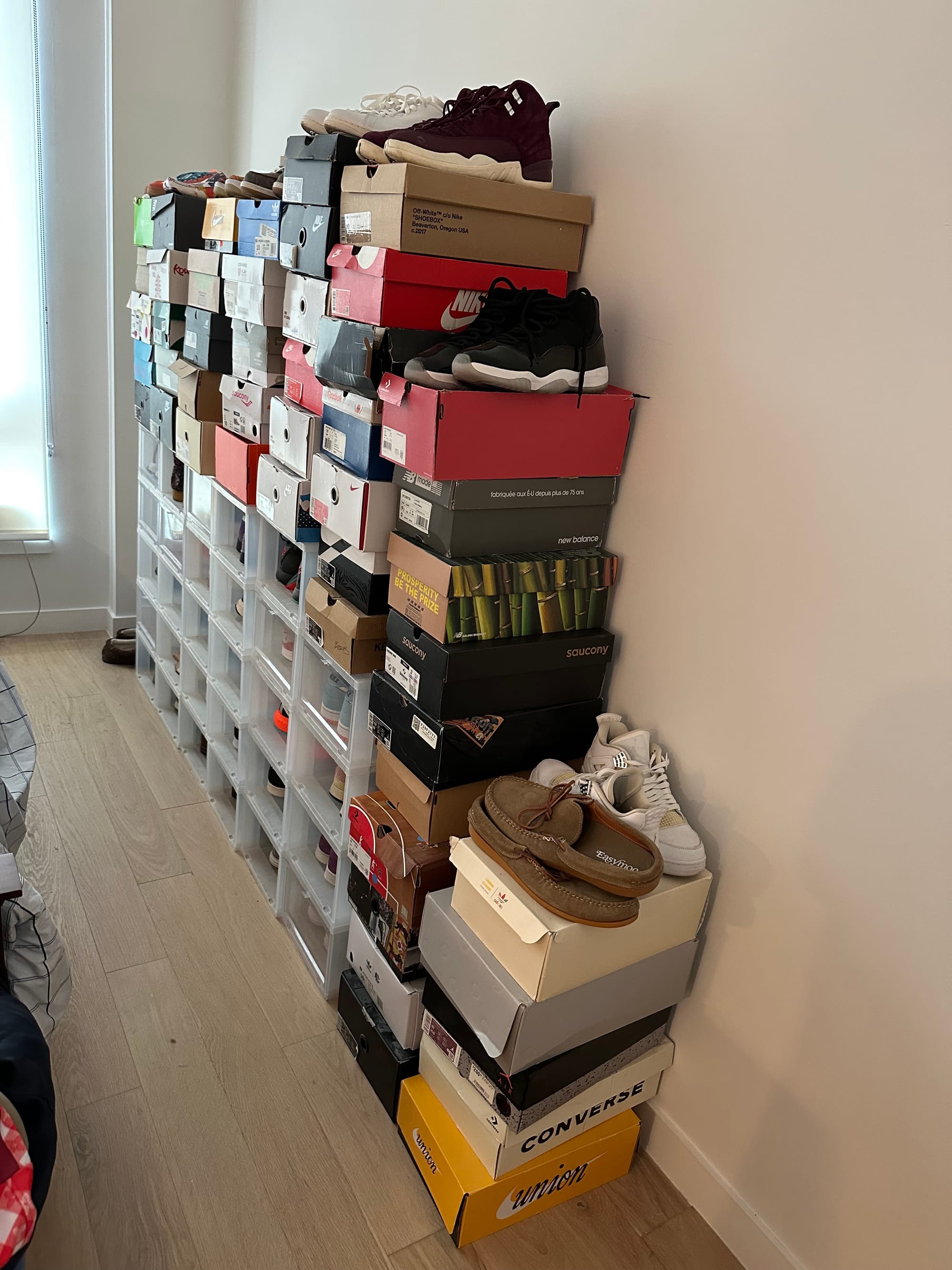 about seventy pairs of shoes, many in clear plastic boxes on display but several in cardboard shoe boxes, some loose on top
