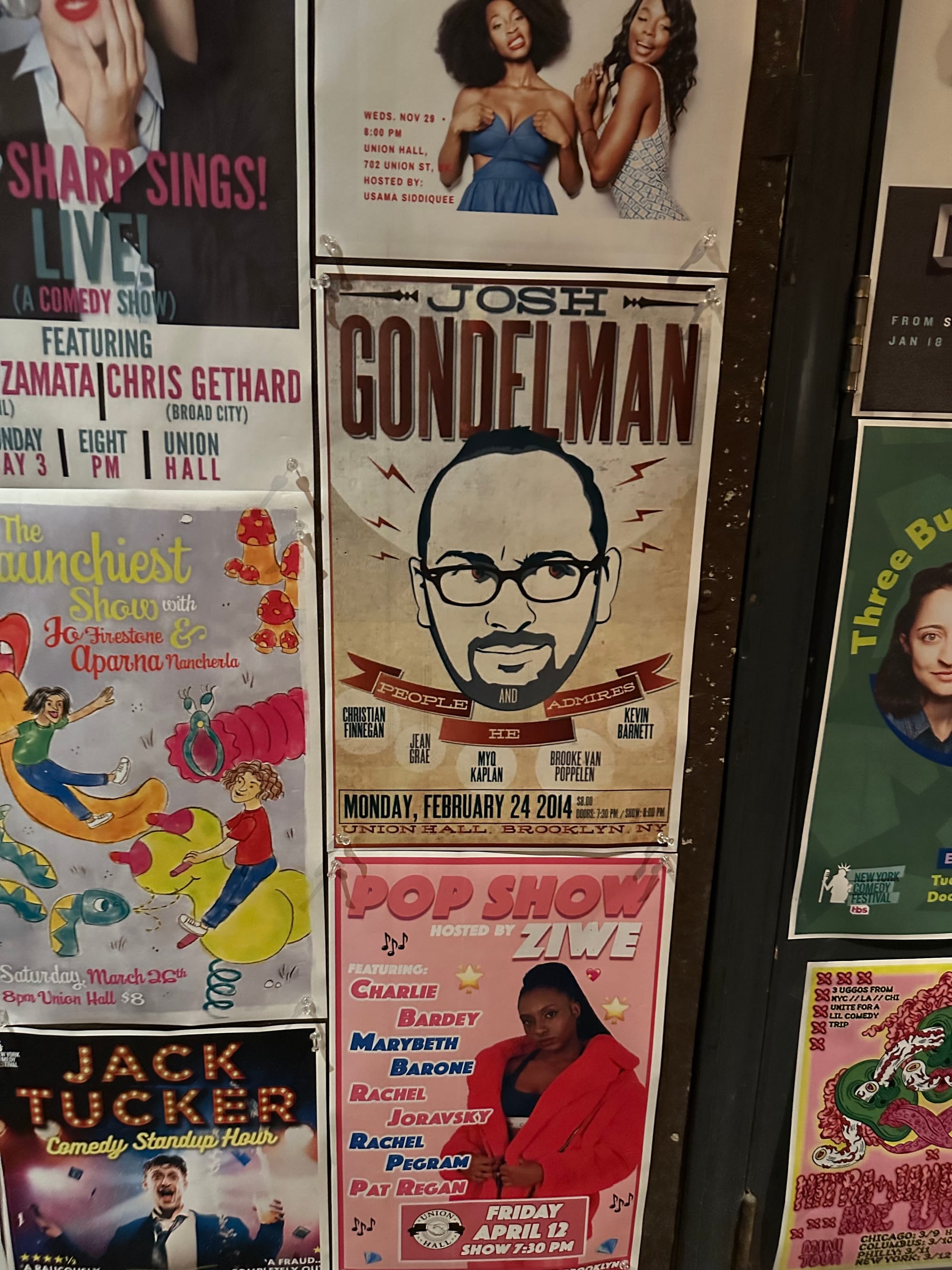 Wall of Fame at UH including posters for Josh Gondelman and People He Admires, Jack Tucker Comedy Standup Hour, Pop Show with Ziwe, Three Busy Debras, and a show hosted by Aparna Nancherla and Jo Firestone.
