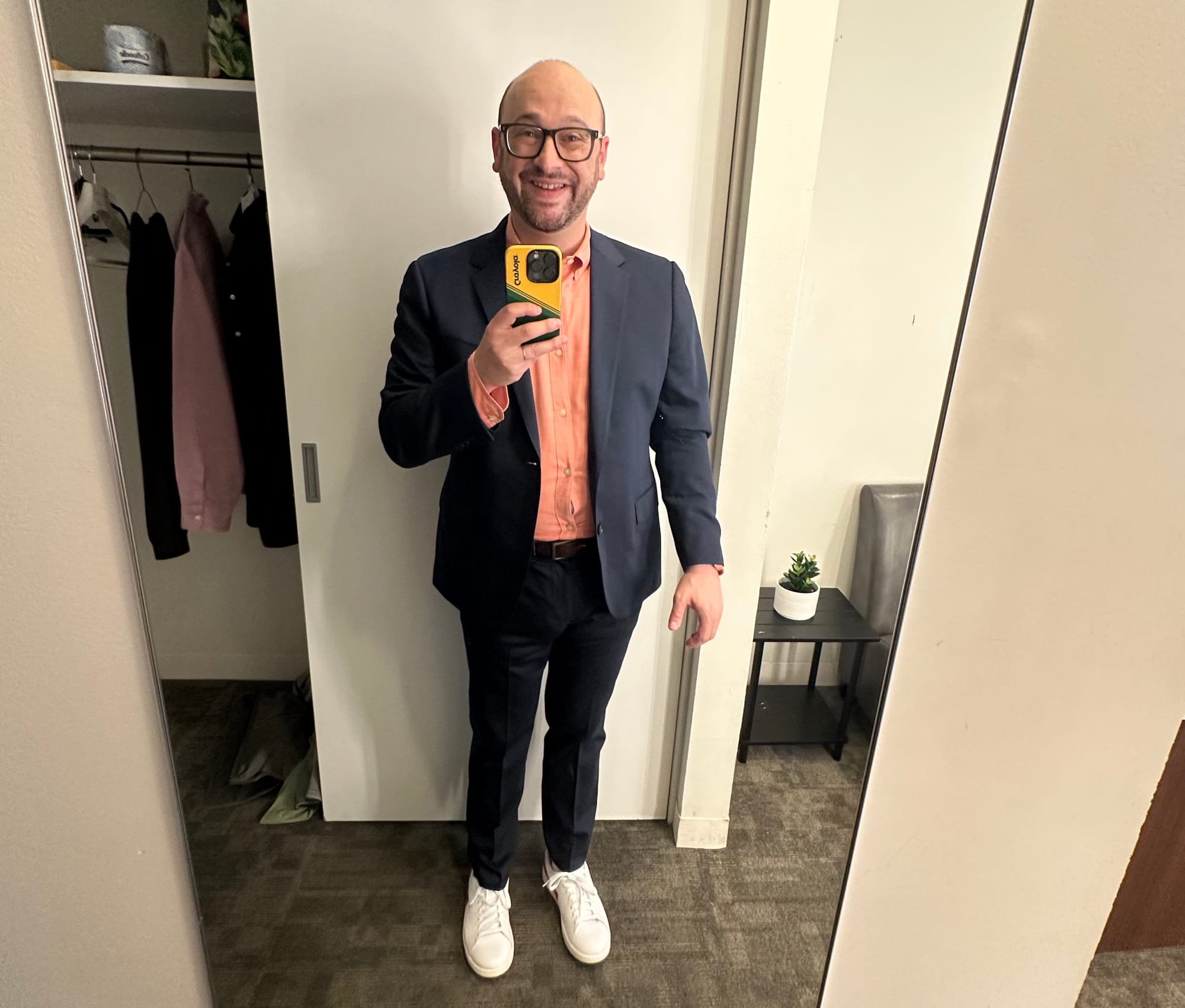 I'm standing in my dressing room at HIGNFY wearing a navy suit and a pink shirt. White sneakers too.