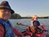 Selfie of a couple in a two-person kayak on a river.