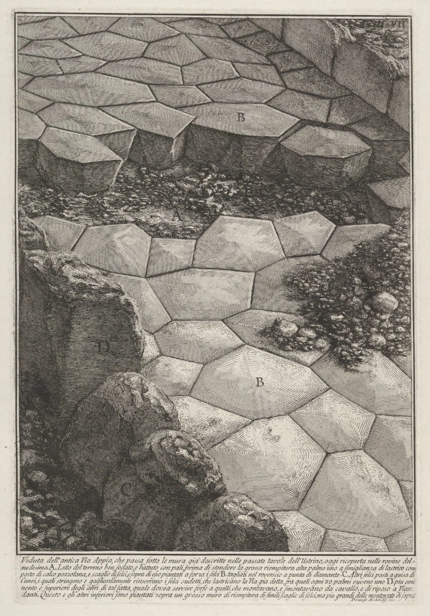 Etching of an ancient road surface of large polygonal paving stones, partly broken open to show the layers beneath, with lettered details and a long engraved caption 