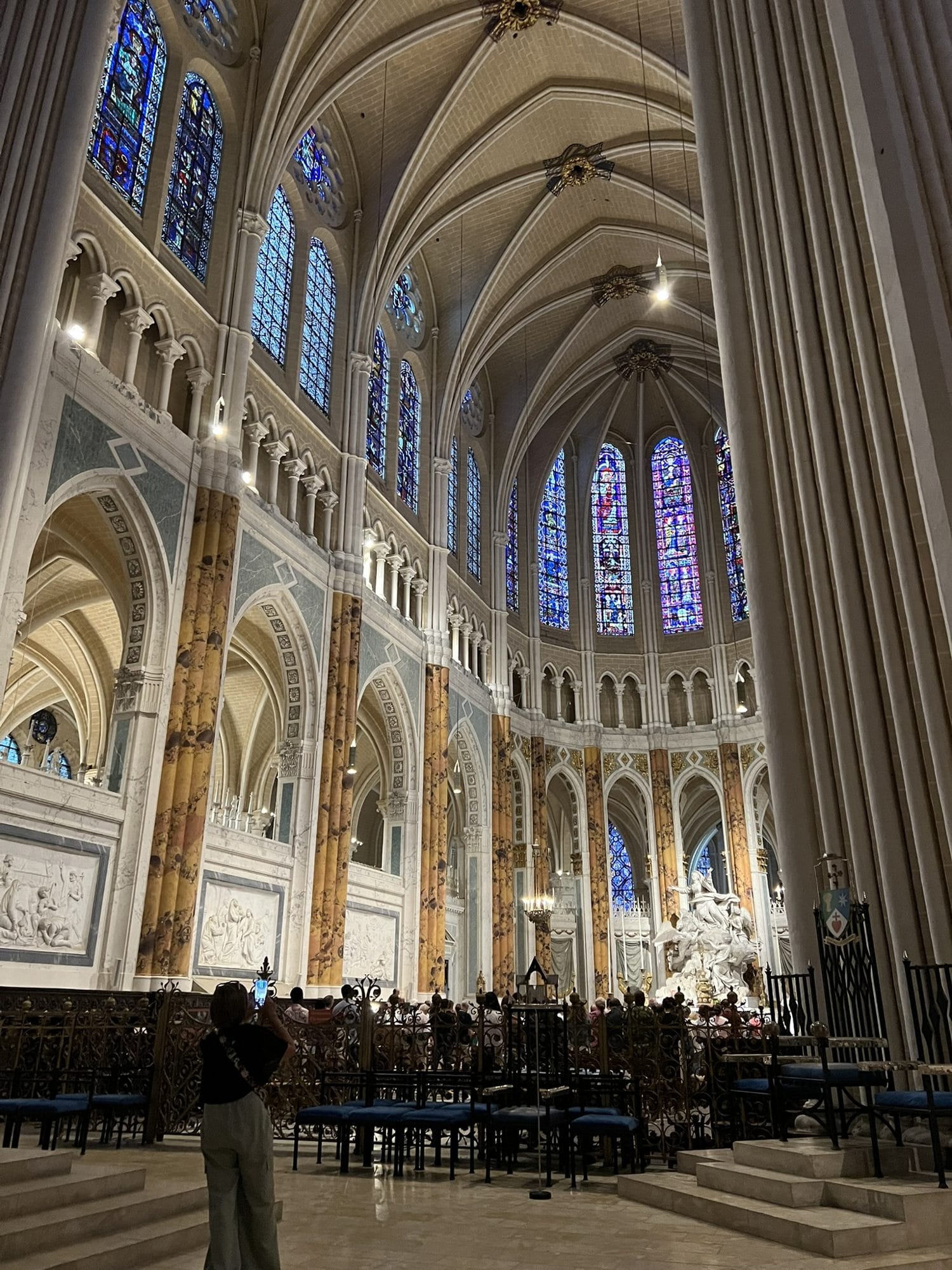 The choir of Chartres Cathedral with columns painted as faux marble, the apse windows and pale vaults