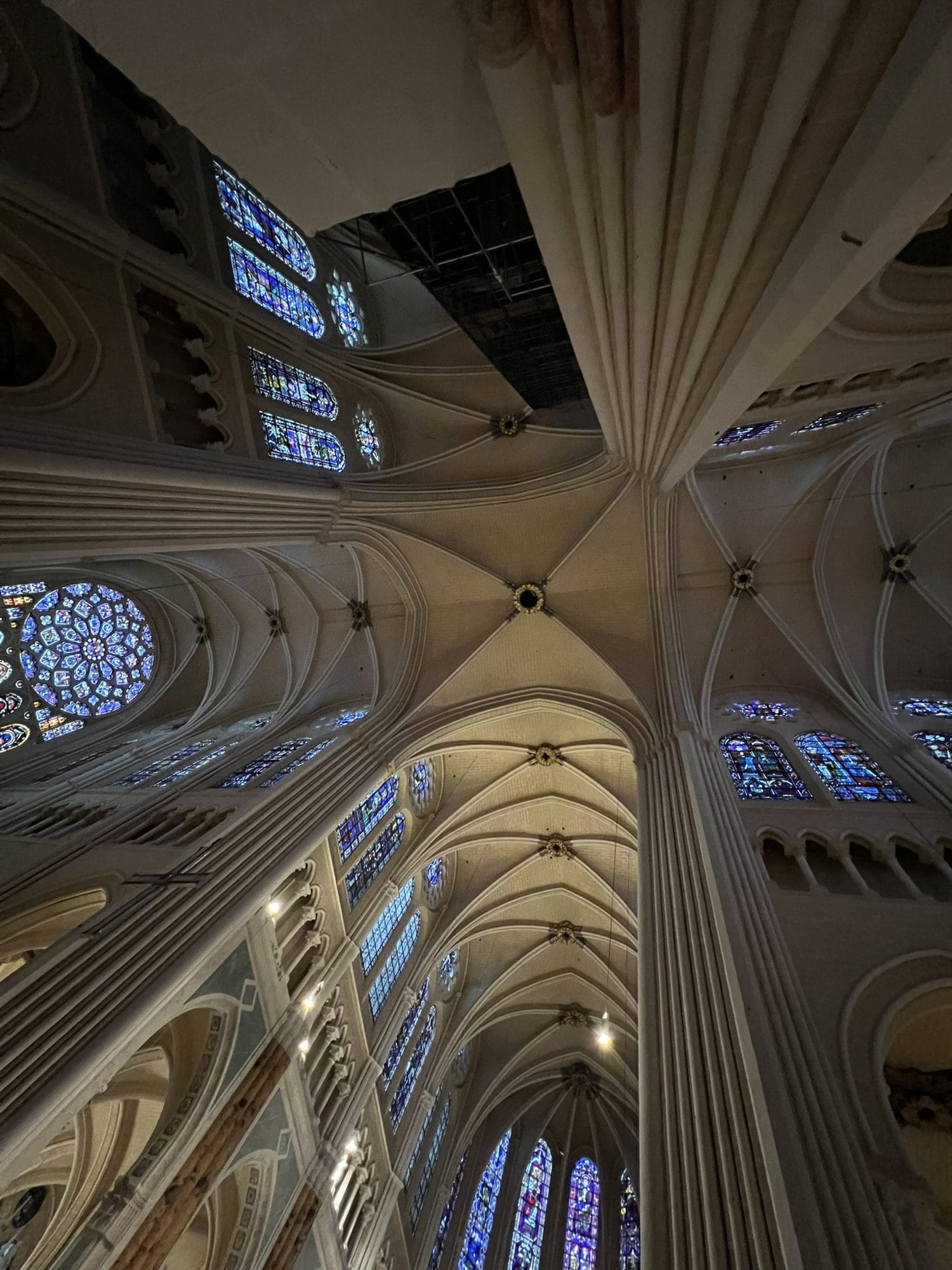 The vaults of the crossing at Chartres seen from directly beneath, with clustered piers rising towards blue stained-glass windows