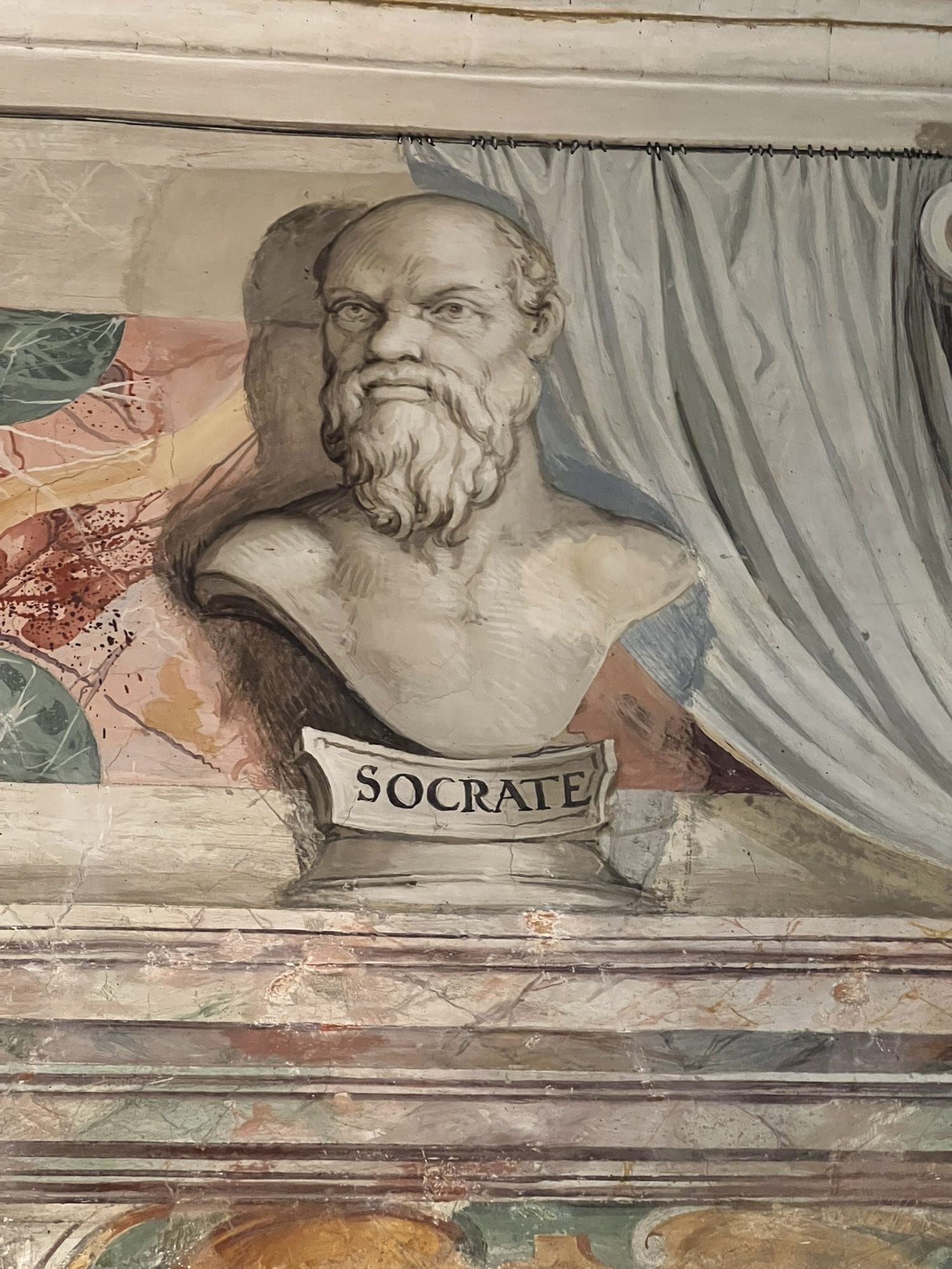 Trompe-l'oeil bust of a bearded philosopher on a pedestal inscribed SOCRATE, in front of a painted curtain
